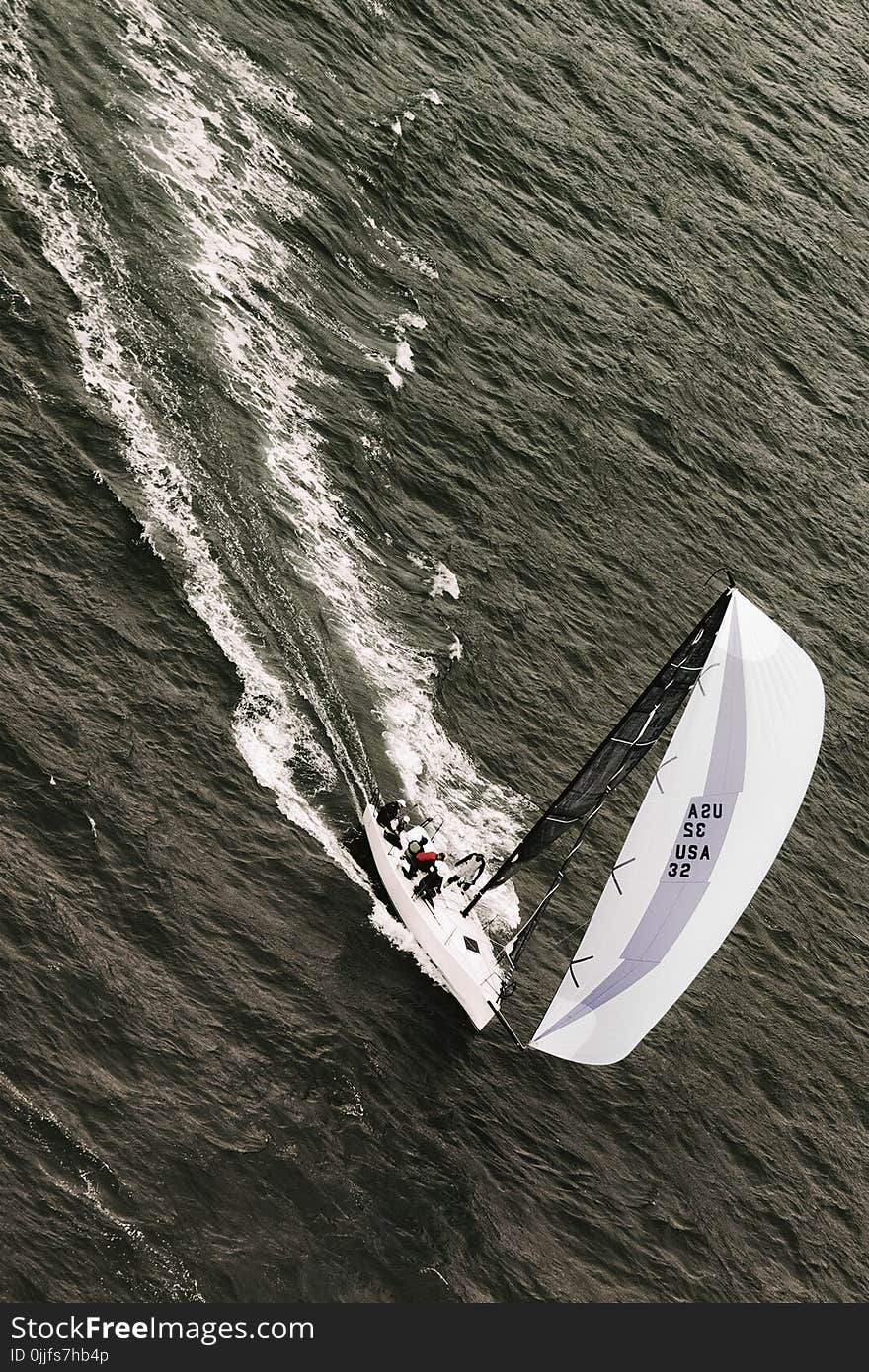 People Riding on White Sailboat on Body of Water