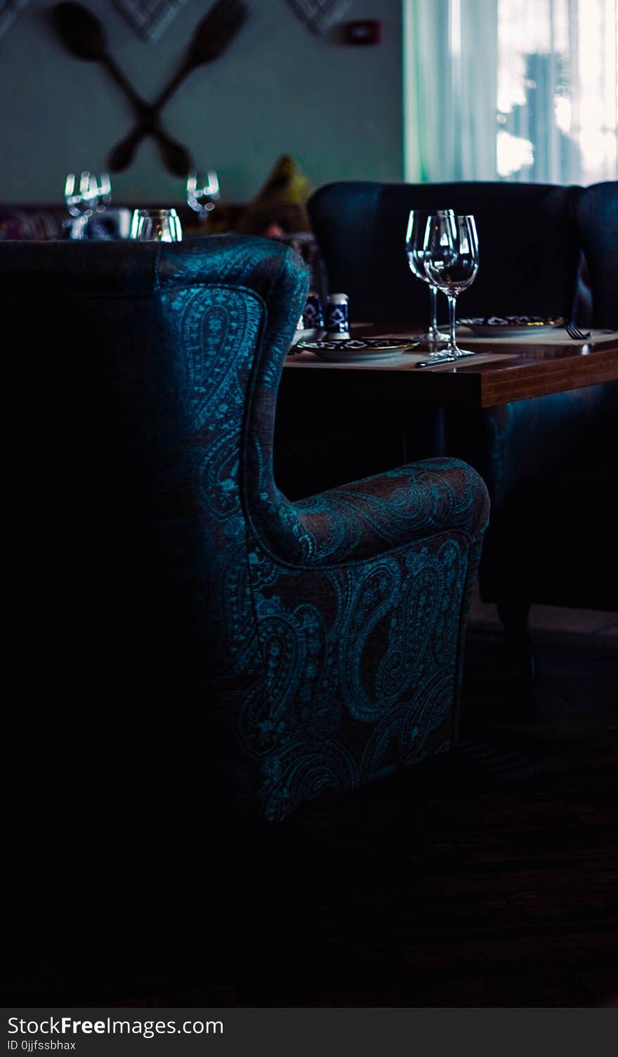 Water Goblets on Brown Wooden Table With Sofa Chairs