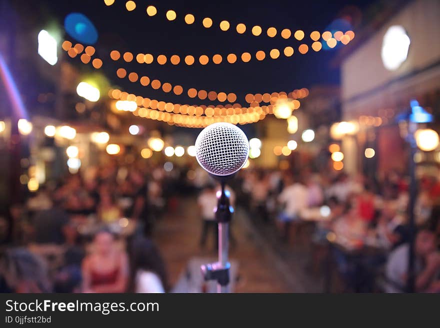 Selective Focus Photo of a Microphone in Front of Audience