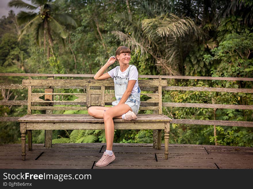 Woman Sitting on Brown Wooden Chair