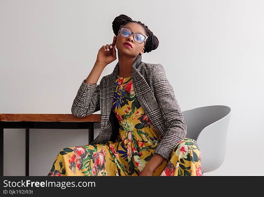 Woman Sitting on Chair While Leaning on Table