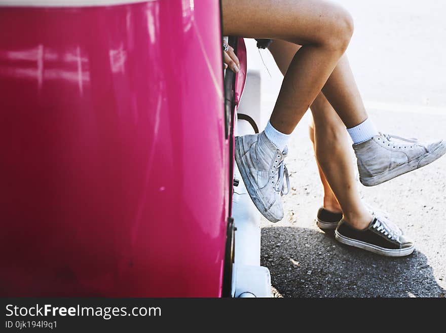 Two Female Sitting on Pink Car