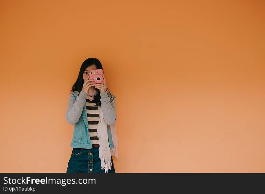 Woman in Blue Jacket Holding Pink Fujifilm Instax Camera