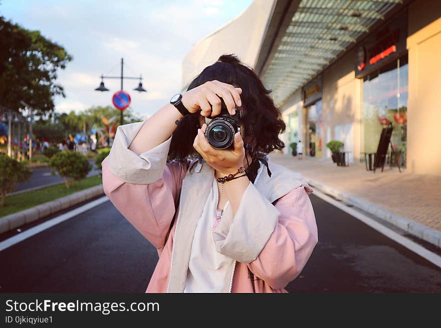 Woman Wearing Pink Coat Holding Dslr Camera