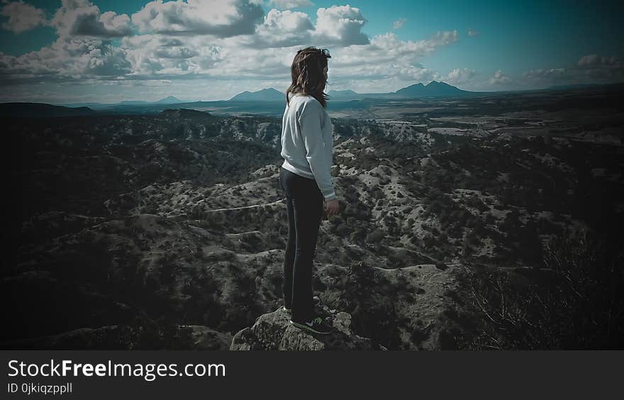 Person in Gray Long-sleeved Shirt Standing on Top of Mountain