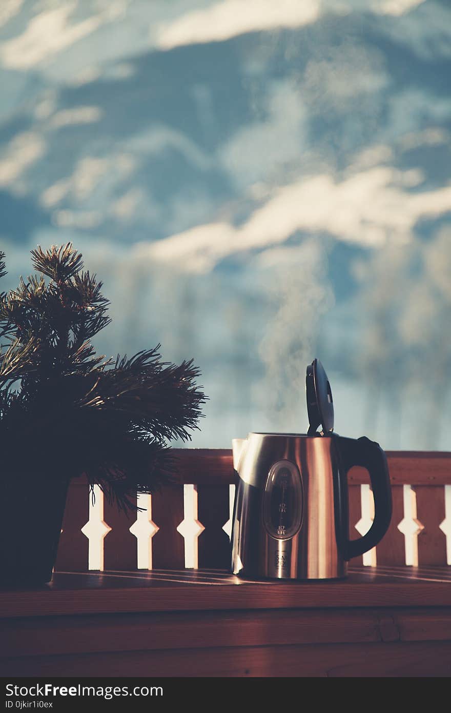 Selective Focus Photography of Silver Electric Kettle Beside Gray Balustrade