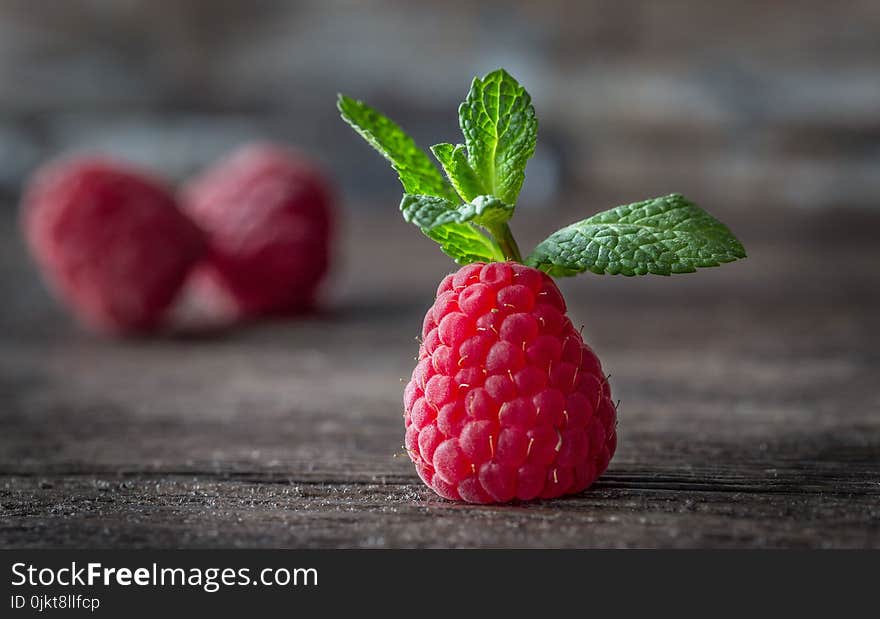 Ripe raspberries and mint on a wooden background