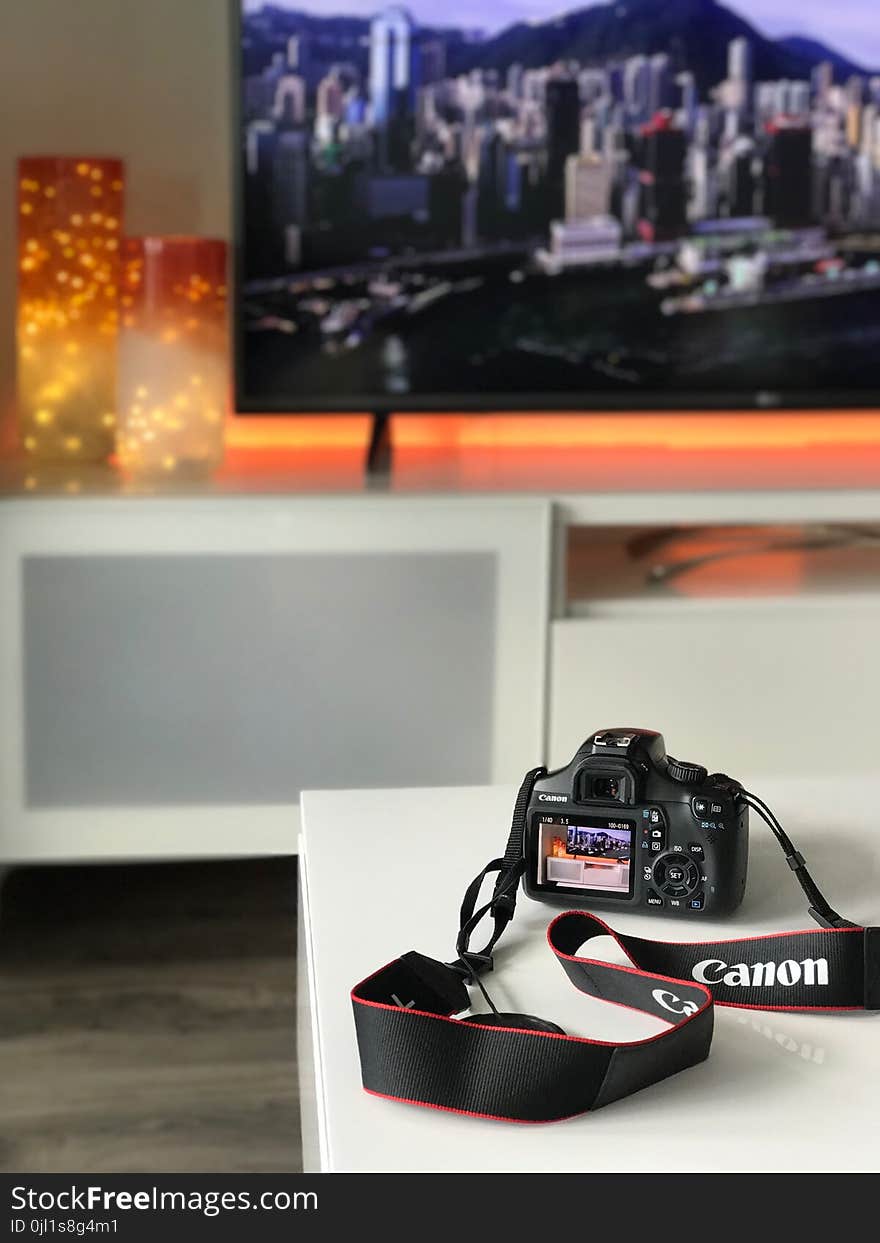 Black Canon Camera on White Wooden Table