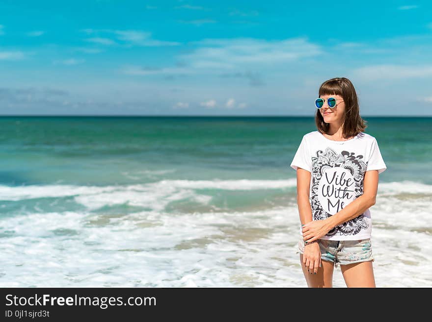 Woman in White Crew-neck Shirt Near Sea Shore