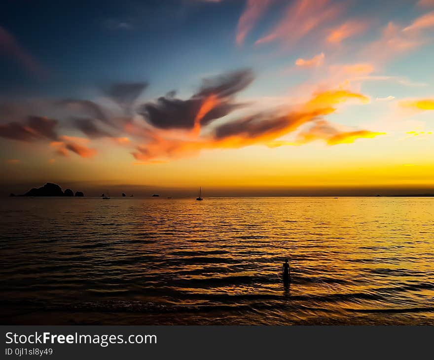 Body of Water Under Calm Sky during Golden Hour