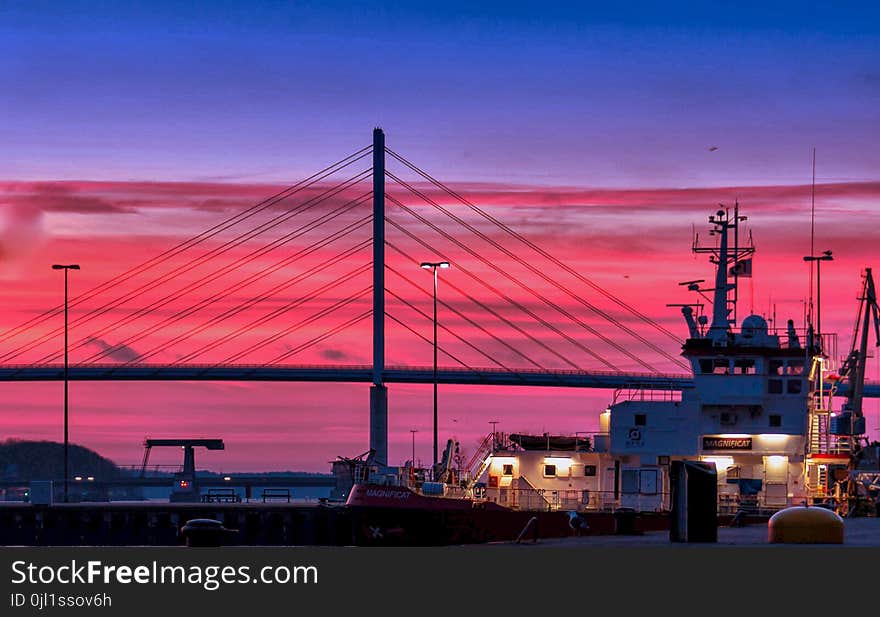 Silhouette of a Bridge Under Red Clouds and Blue Sky Taken during Night Time