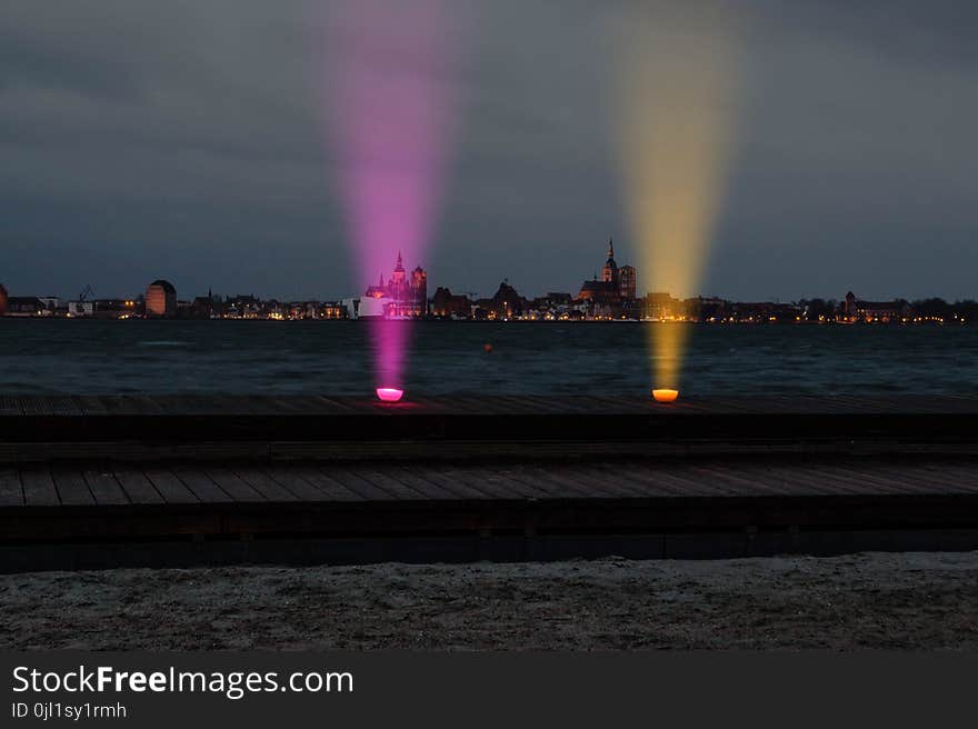 Two Purple and Orange Lights on Top of Brown Surface