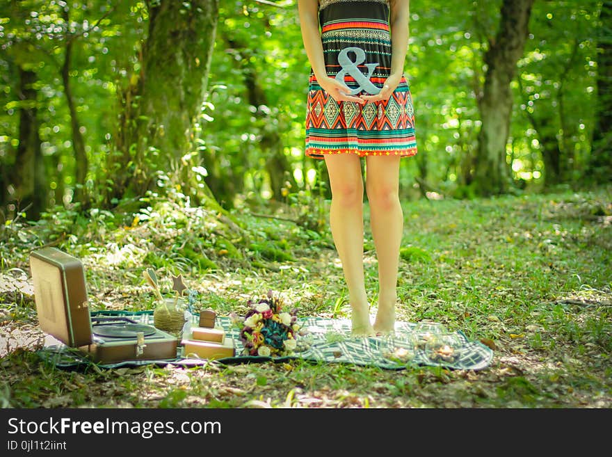 Woman Standing on Picnic Mat Holding Ampersand Lettering