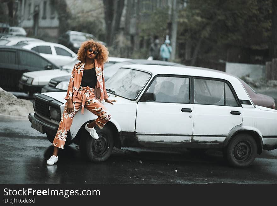 Woman Wearing Black Shirt With Brown Cardigan Sitting on White Sedan