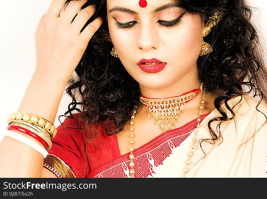 Beautiful indian woman in a red saree and gold jewellry. Beautiful indian woman in a red saree and gold jewellry