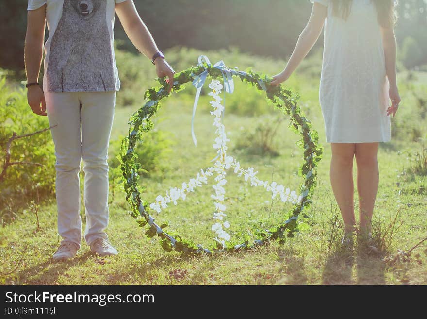 Two Person Holding White and Green Peace Wreath