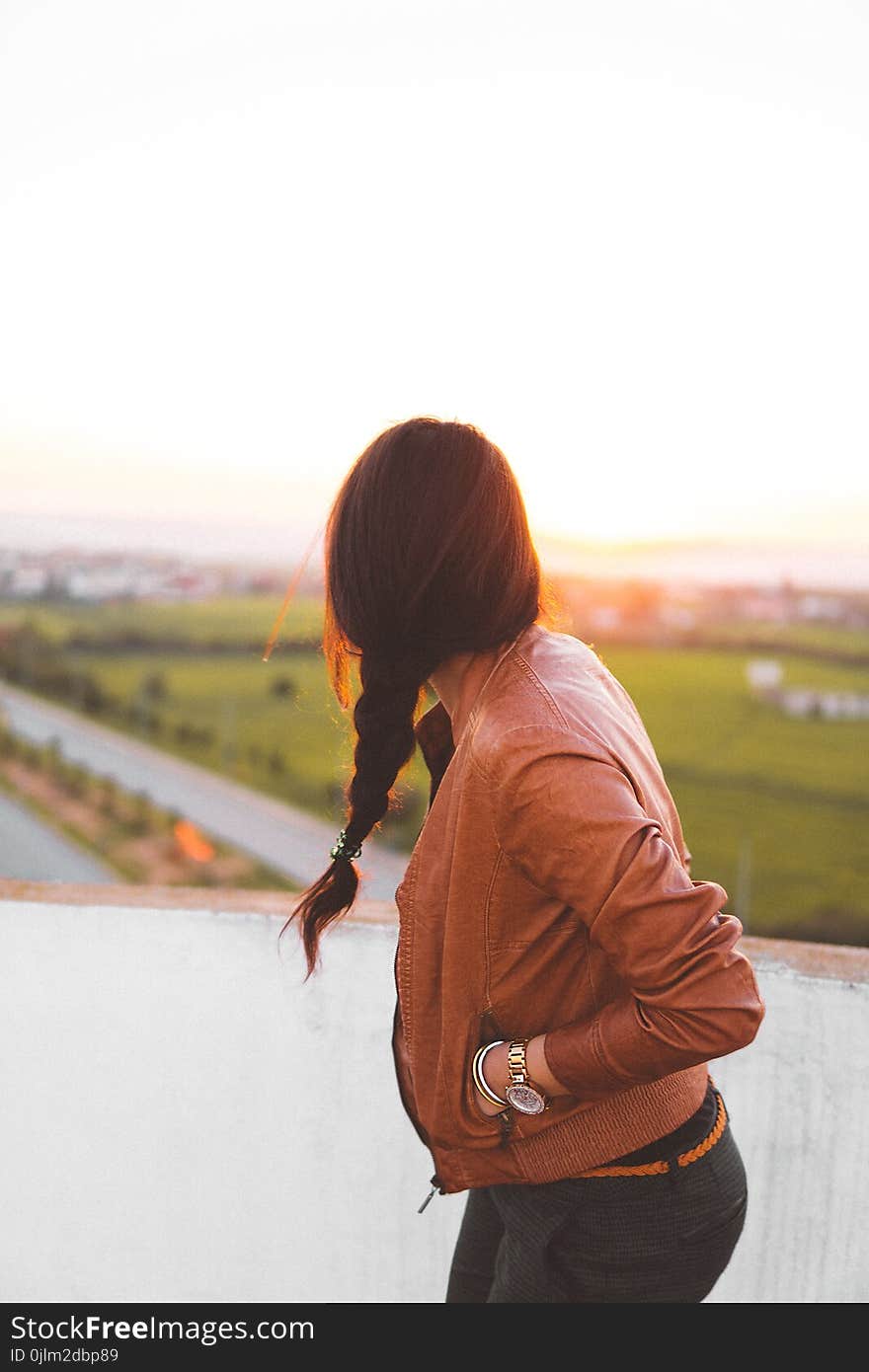 Woman Wearing Brown Leather Jacket Standing and Looking on Grass Field View at Day Time