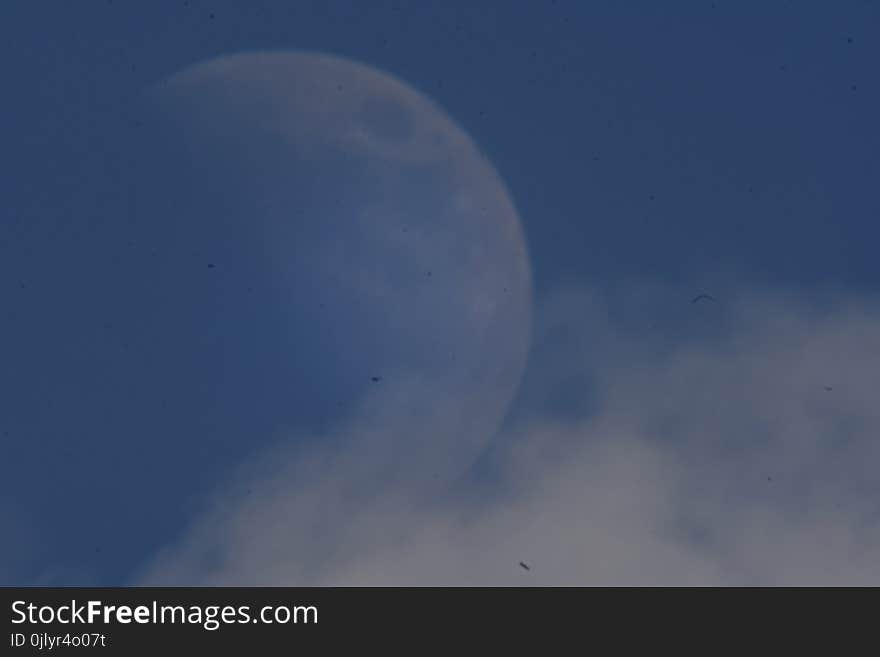 A blue sky with day moon and clouds on a summer`s day. A blue sky with day moon and clouds on a summer`s day.