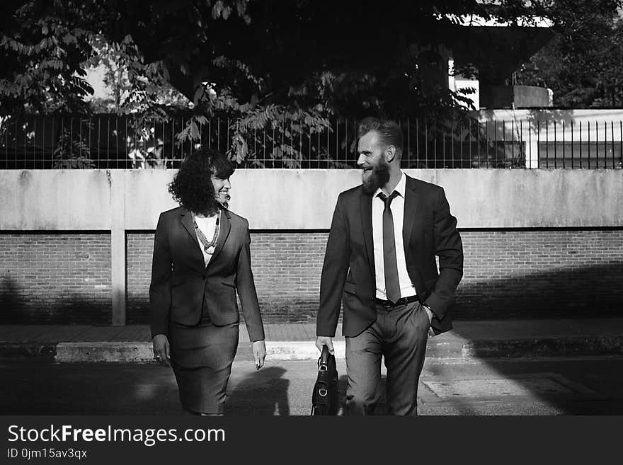 Grayscale Photo of Man and Woman in Formal Suits