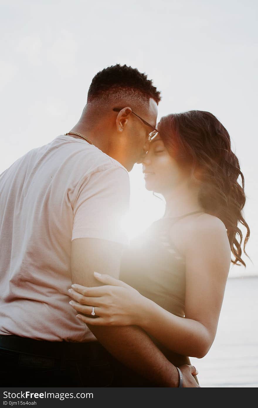 Man Wearing White Shirt Kissing Woman in Her Nose