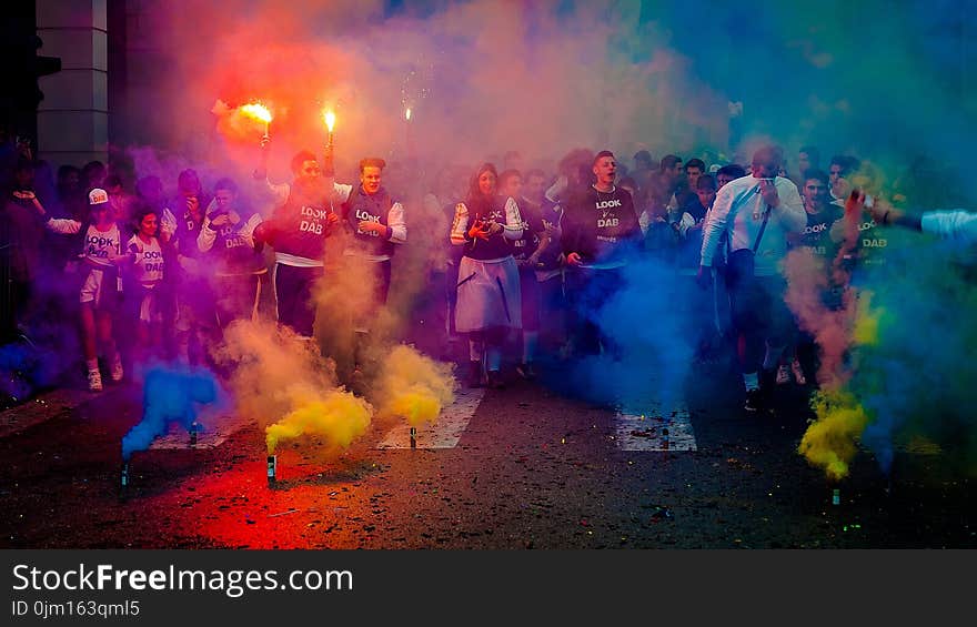 Group of People on Road With Assorted-color Smokes