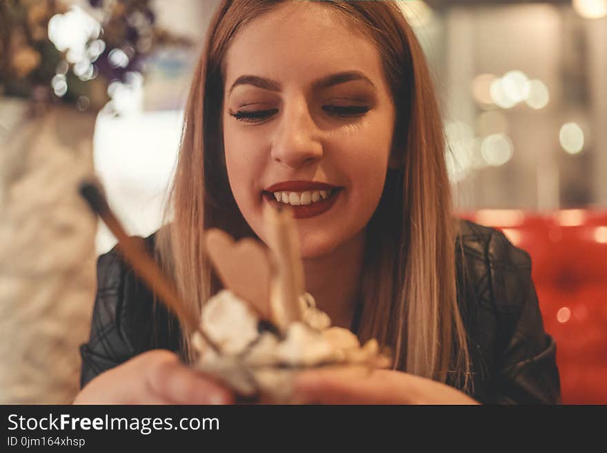 Woman Wearing Black Jacket Holding Cup Filled With Food