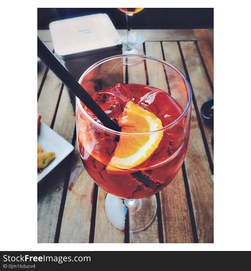 Photo of Wine Glass With Sliced Lemon and Juice on Brown Wooden Panel