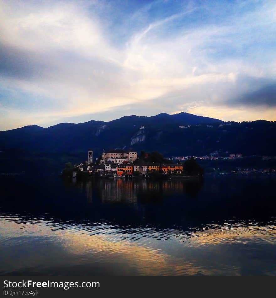 Buildings Near Body Of Water And Mountain