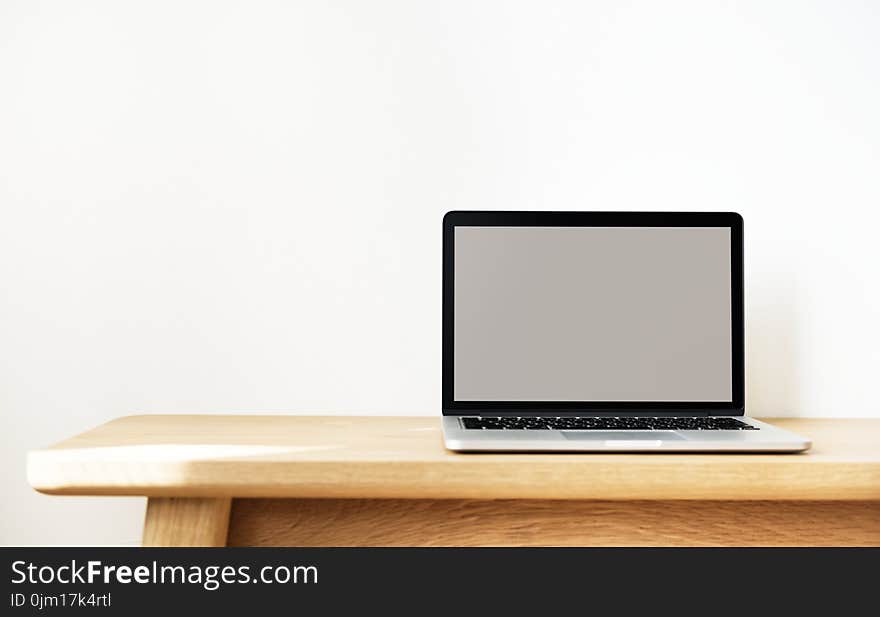 Macbook Pro on Brown Wooden Table