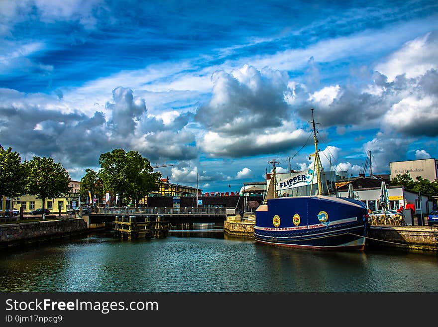 Blue and White Ship in Front of Concrete Structure