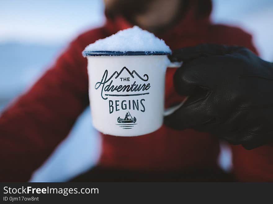 Selective Focus Photography of Person Holding the Adventure Begins Mug