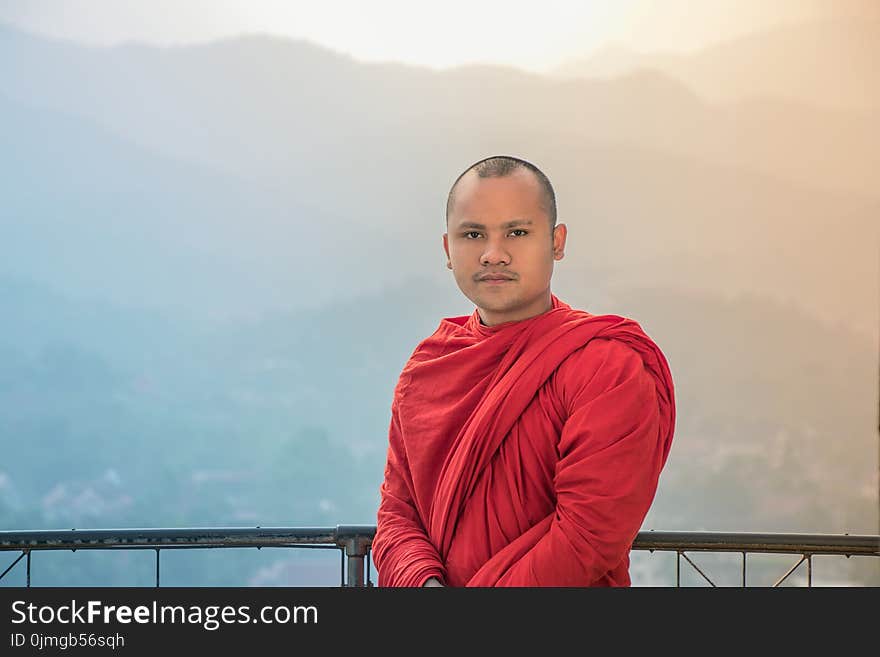 Man in Red Traditional Dress Under White and Blue Sky