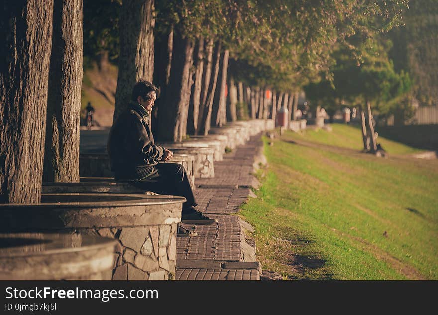 Man Seating on Concrete Base