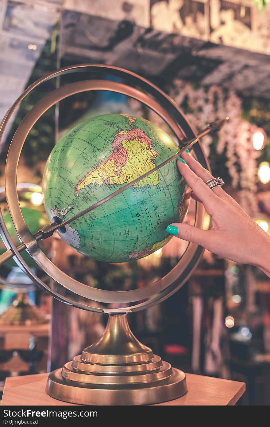 Woman Hand Touches Green Desk Globe