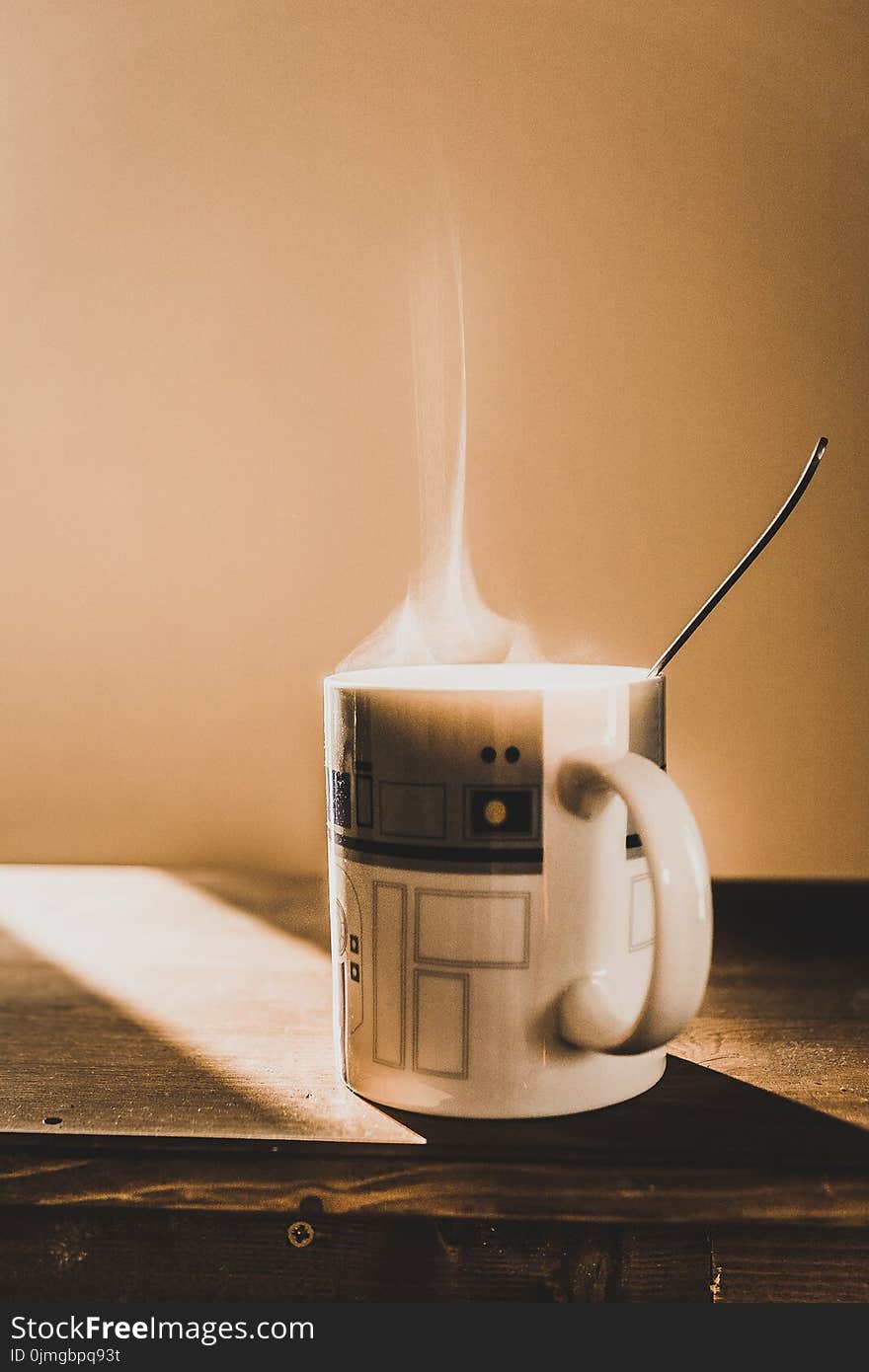 White and Grey Ceramic Mug on Brown Wooden Table