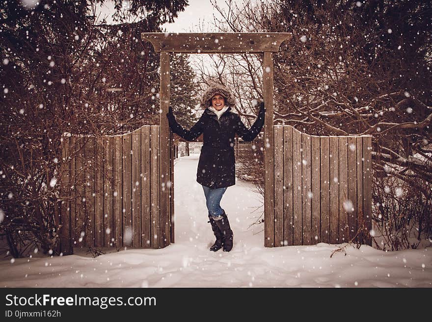 Woman in Black Coat Beside Fence during Snow