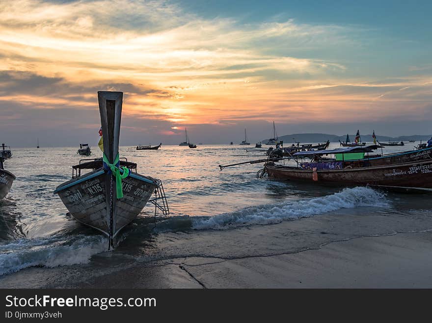 Brown Boat Near Body of Water during Sunset