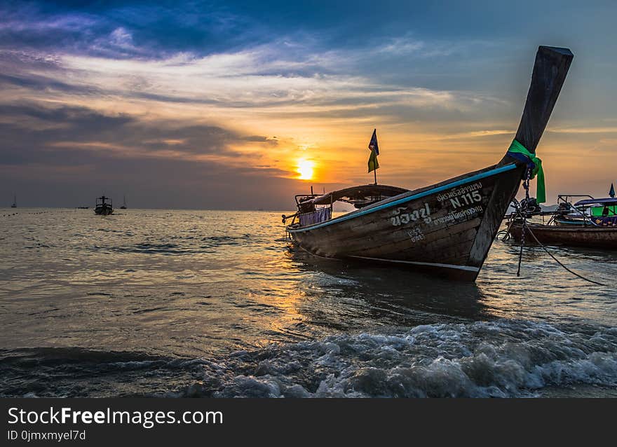 Photo of Brown Boat at Sea during Golden Hour