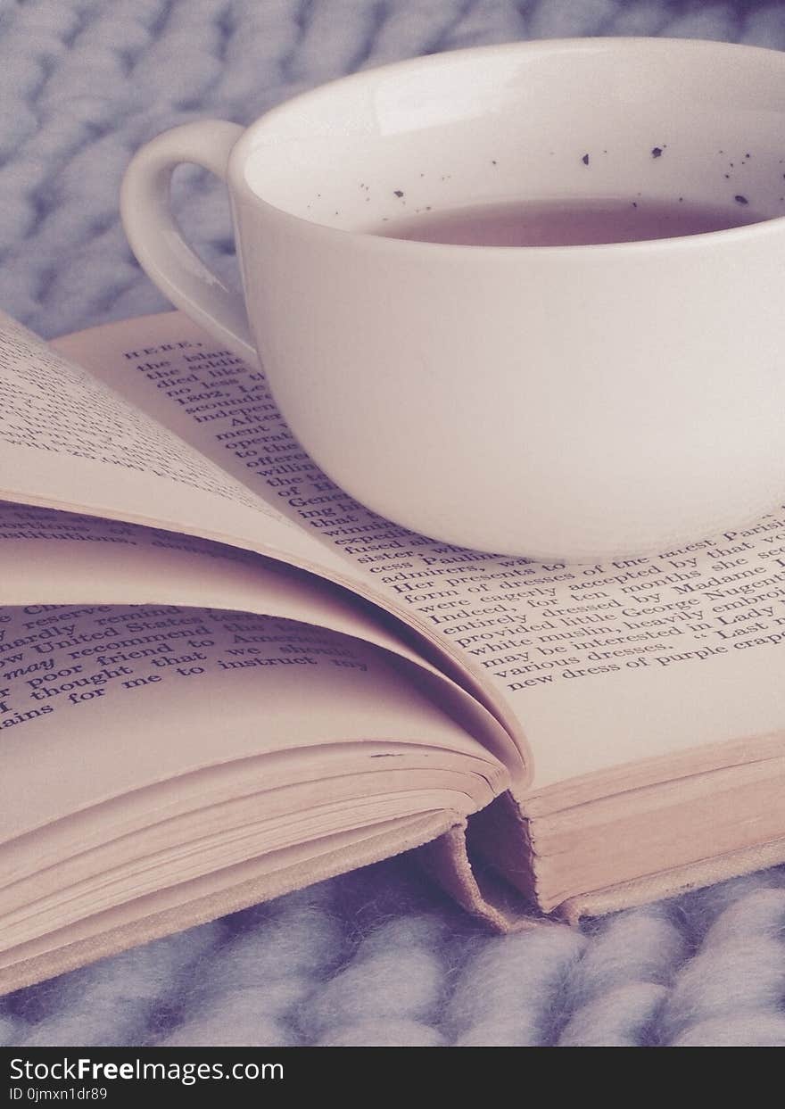 White Ceramic Cup on Top of Book