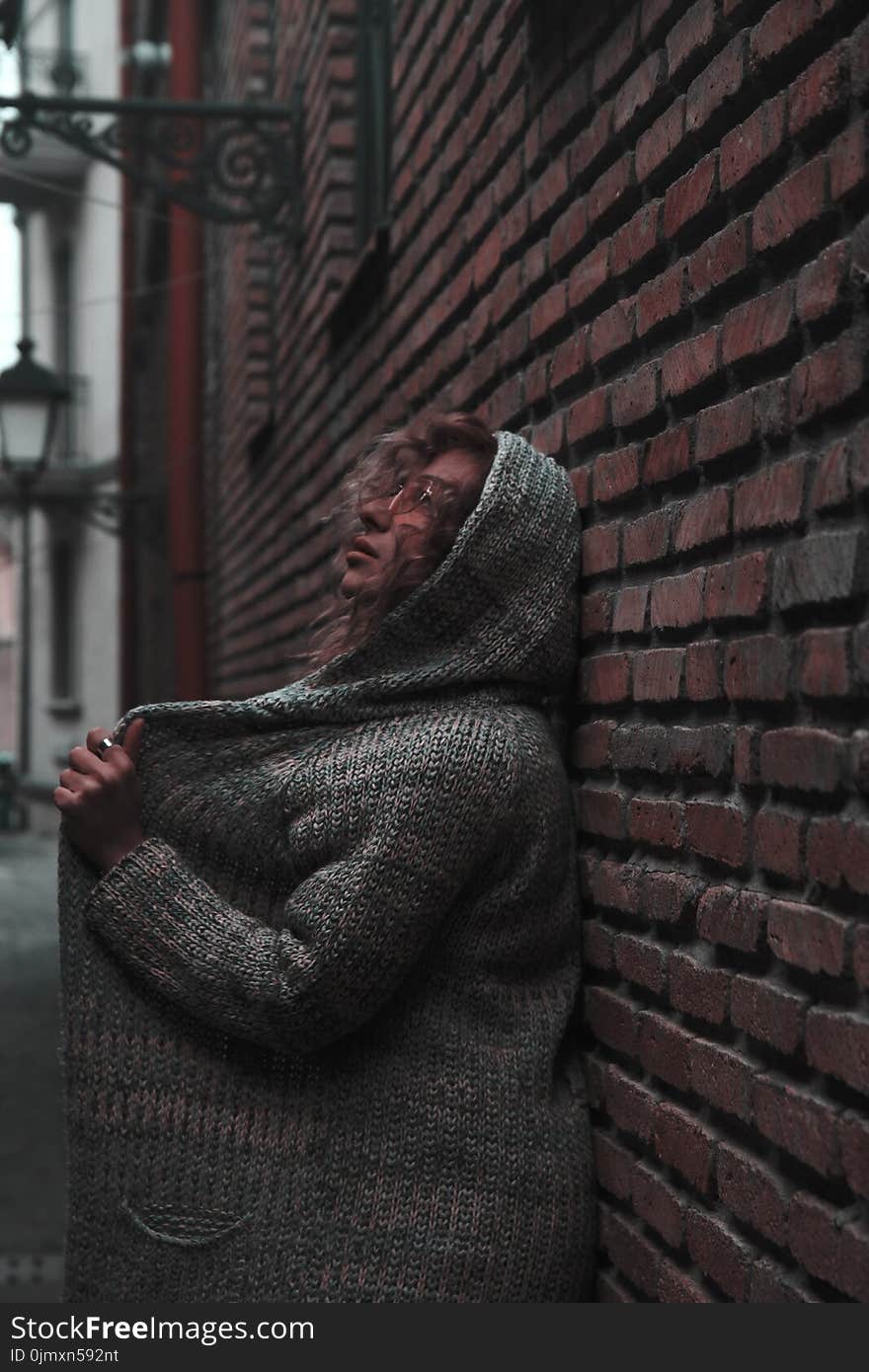 Woman in Orange Sunglasses With Space-dye Cardigan With Hoodie Leaning on Wall Brick