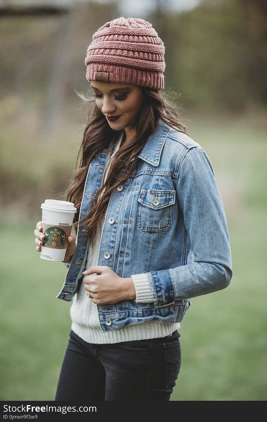 Woman Wearing Blue Denim Jacket and Pink Knit Cap Holding Starbucks Coffee