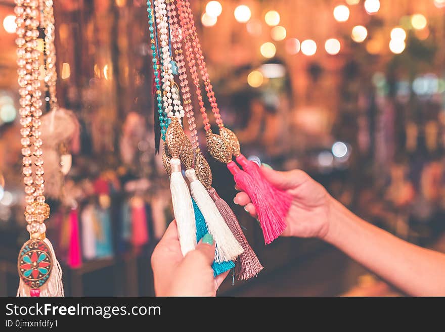 Person Holding Assorted-colored Tassel Necklace Lot