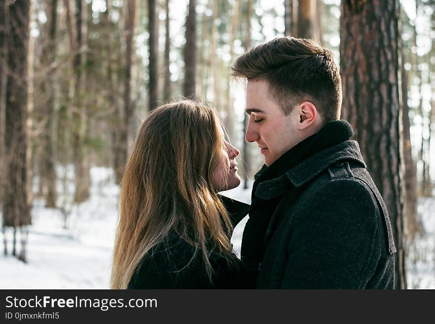 Man Wearing Black Coat Facing Woman Wearing Black Coat Near Tree