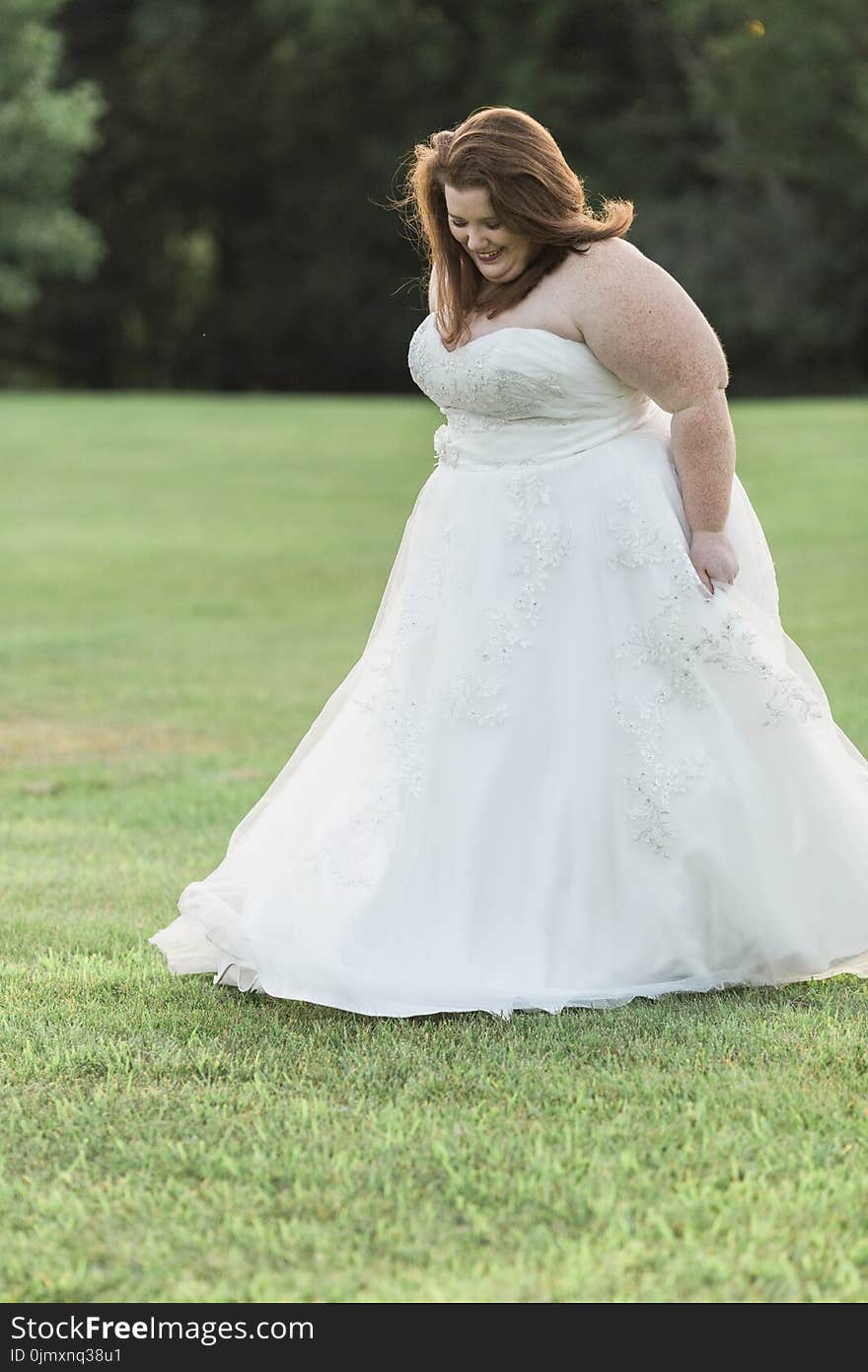 Woman in White Floral Wedding Gown Walks on Green Grass Lawn Yard