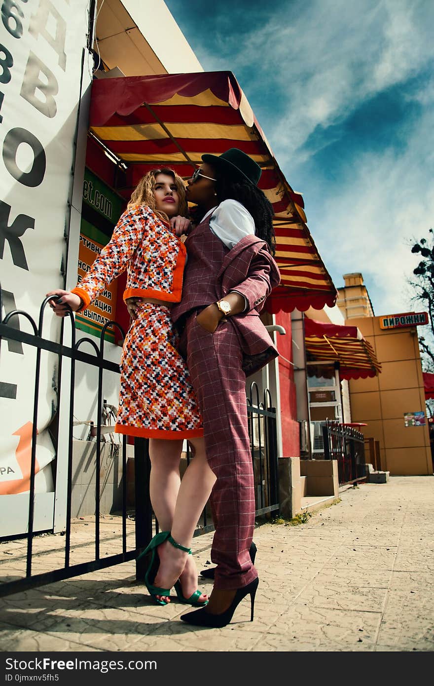 Two Women Standing Near White Building