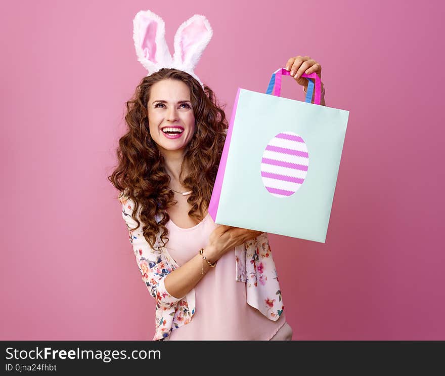 Happy woman with Easter shopping bag looking at copy space