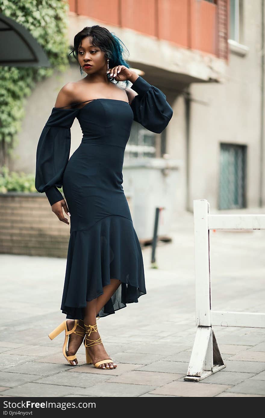 Woman Wearing Off-shoulder Standing Next to White Road Blockage