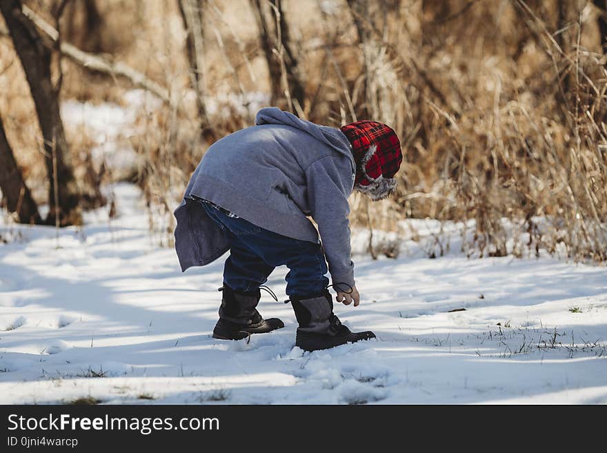 Shallow Focus Photography Kid Wearing Gray Jacket on Snow Covered Field