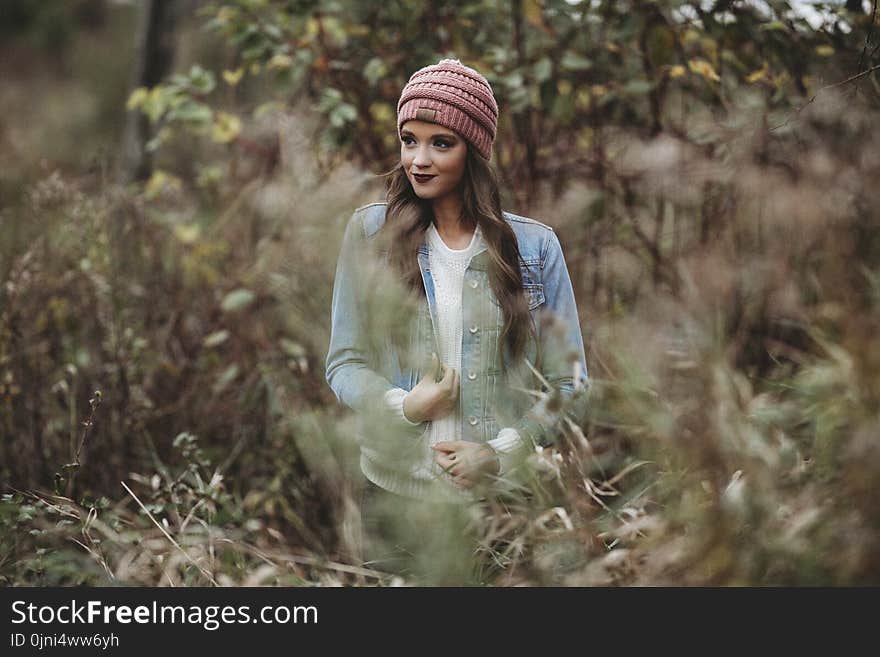 Woman Wearing Denim Jacket Near Trees and Bush