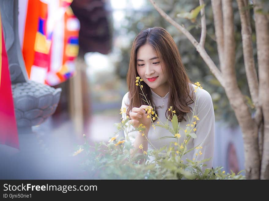 Woman Wearing White Long-sleeved Top Holding the Flower